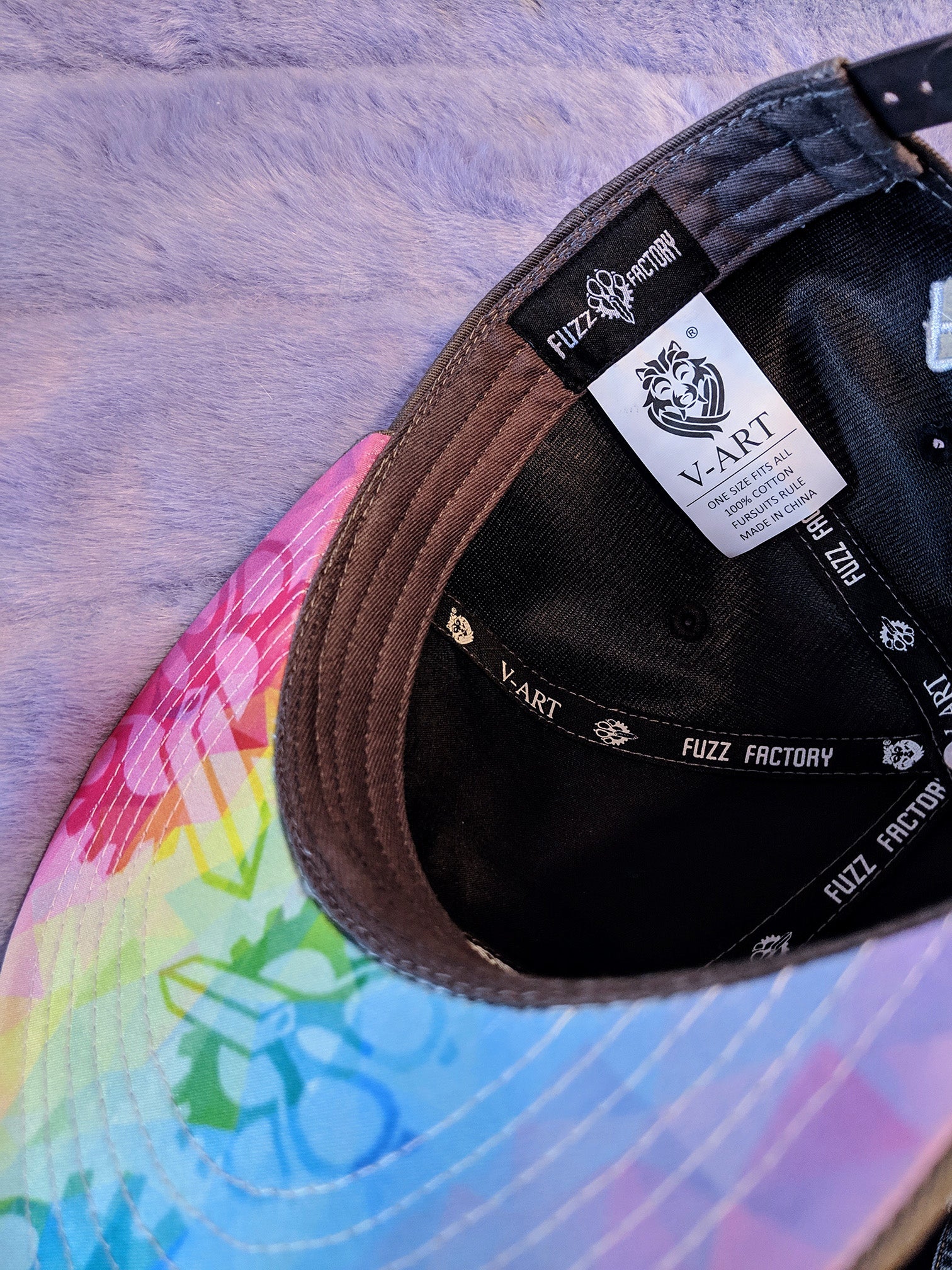 Black cap with 'V-Art' and 'Fuzz Factory' branding on a fur background