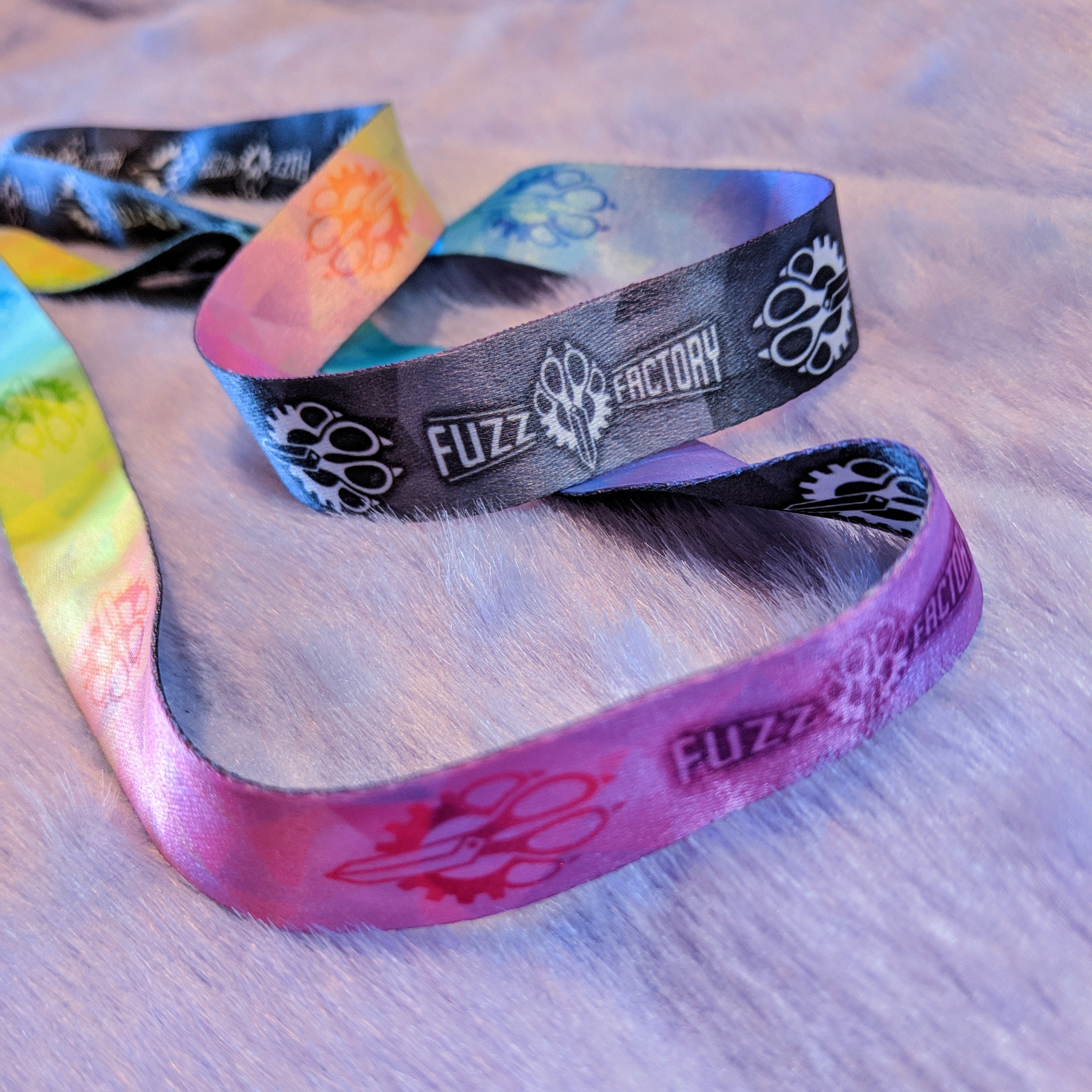 Colorful lanyards with 'Fuzz Factory' branding on a textured surface